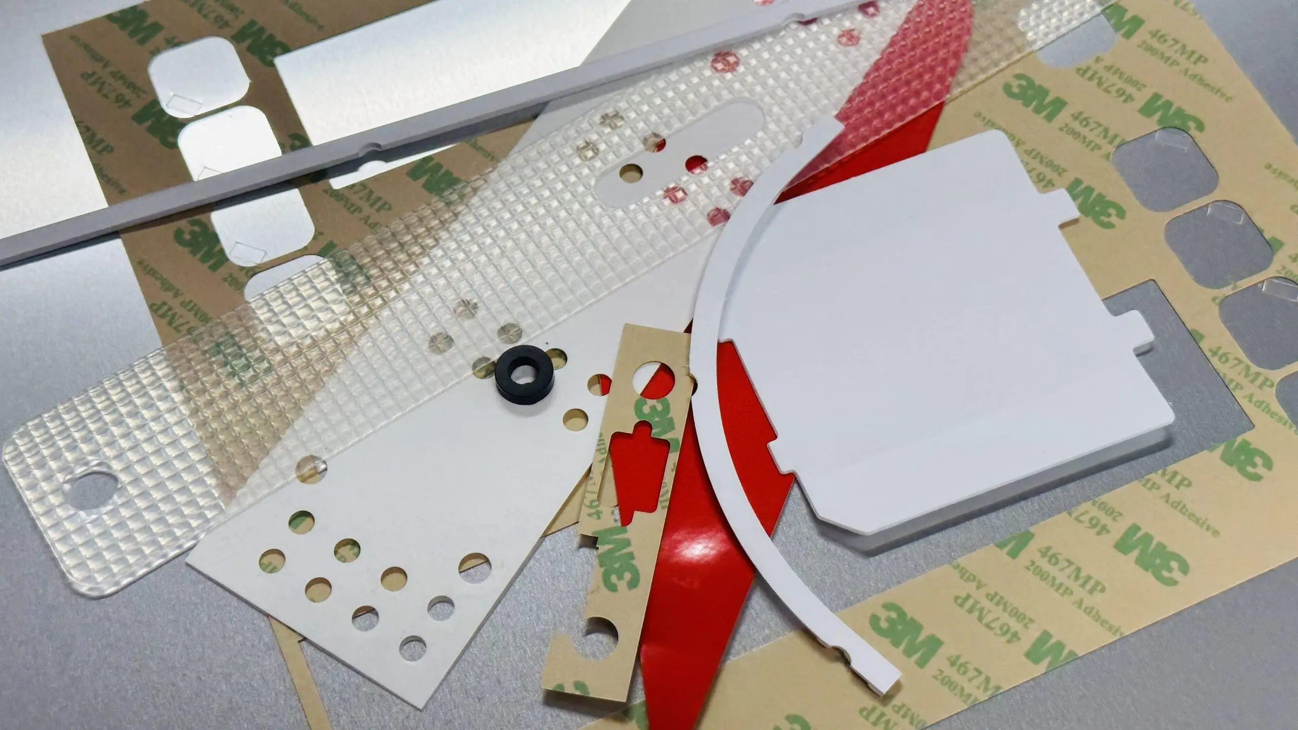 Assorted custom die-cut components including foam, film, and adhesive-backed parts made in the Bay Area, CA for OEM applications.