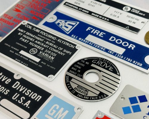 Assorted custom metal nameplates for industrial equipment and branding, manufactured near San Jose, CA.