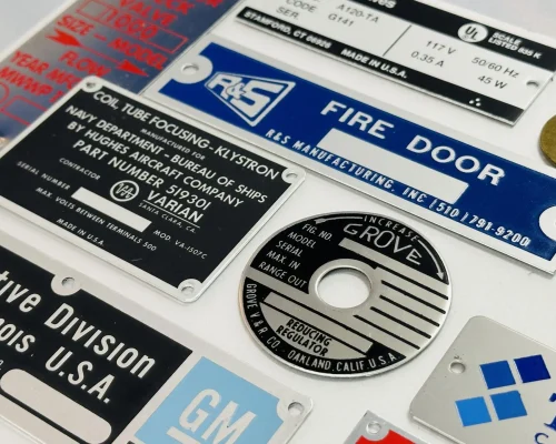Assorted custom metal nameplates for industrial equipment and branding, manufactured near San Jose, CA.